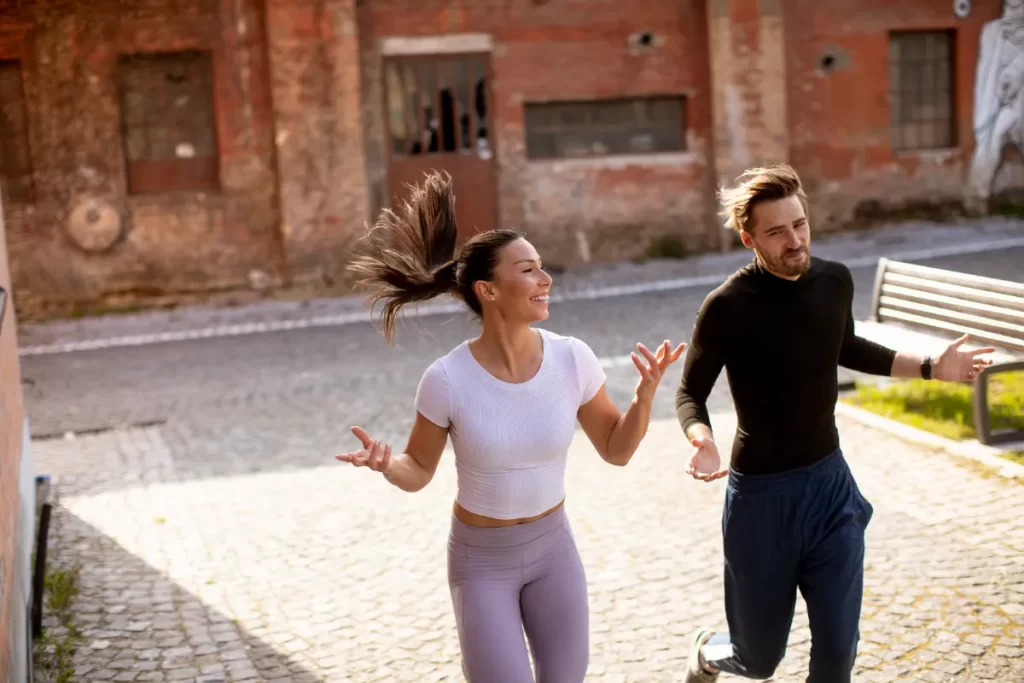 young fitness couple running in urban area utc