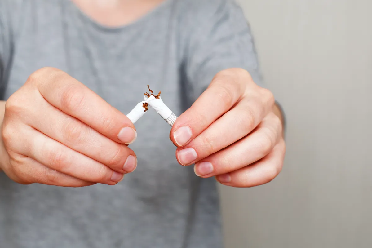 young woman holding broken cigarette in her hands utc