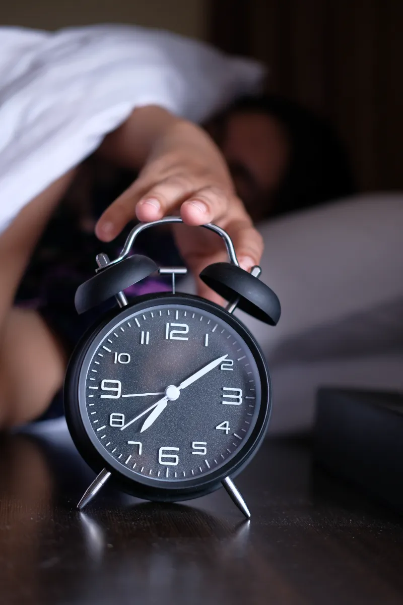 a person reaches for the alarm clock on their beds utc