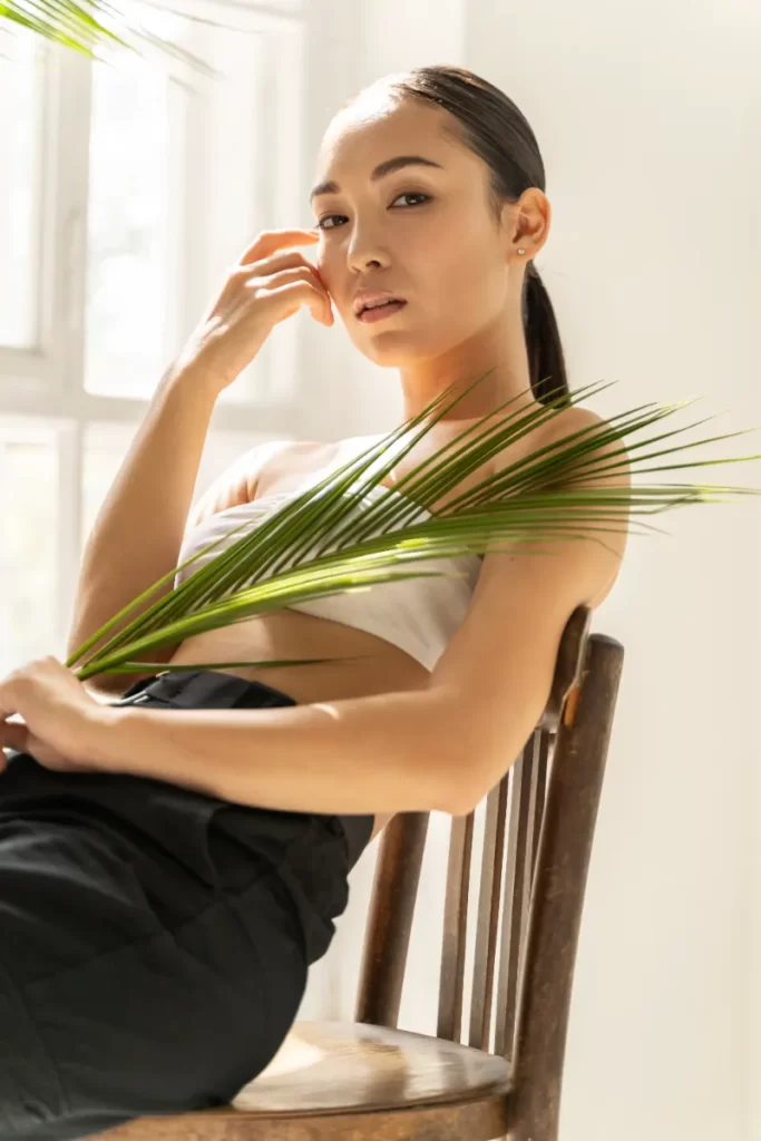 beautiful lady resting with palm leaf in room utc
